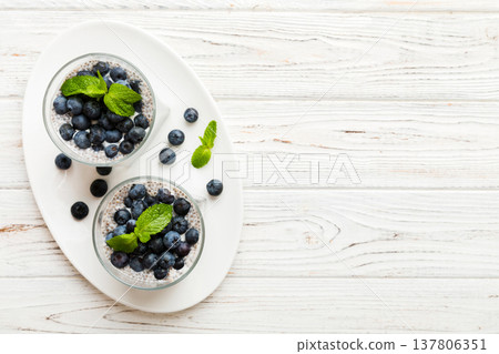 Healthy breakfast or morning with chia seeds vanilla pudding and blueberry berries on table background, vegetarian food, diet and health concept. Chia pudding with coconut milk and blueberry Healthy breakfast or morning with chia seeds vanilla pudding and blueberry berries on table background, vegetarian food, diet and health concept. Chia pudding with coconut milk and blueberry 137806351