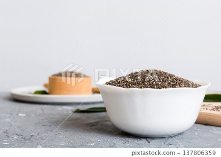 Chia seeds in bowl on colored background. Healthy Salvia hispanica in small bowl. Healthy superfood Chia seeds in bowl on colored background. Healthy Salvia hispanica in small bowl. Healthy superfood 137806359