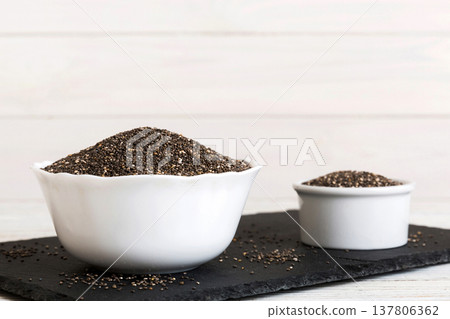 Chia seeds in bowl on colored background. Healthy Salvia hispanica in small bowl. Healthy superfood Chia seeds in bowl on colored background. Healthy Salvia hispanica in small bowl. Healthy superfood 137806362