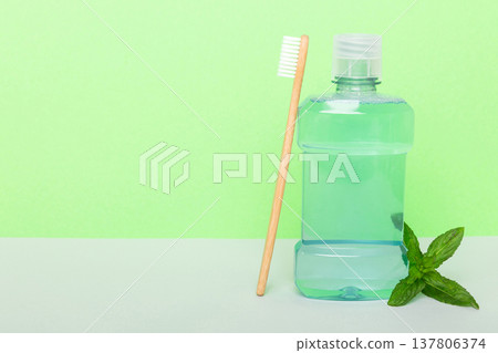 Mouthwash and fresh mint on colored background, top view with copy space for text Mouthwash and fresh mint on colored background, top view with copy space for text 137806374