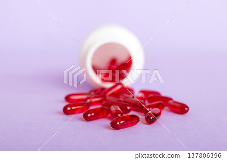 Red pills spilled around a pill bottle. Medicines and prescription pills flat lay background. Red medical capsules 137806396