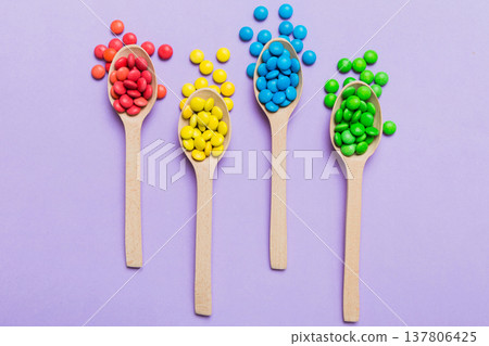 delicious colorful sweet candies on spoon on colored background . Confectionery decor top view with copy space delicious colorful sweet candies on spoon on colored background . Confectionery decor top view with copy space 137806425