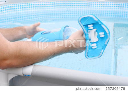 Man assembles a swimming pool vacuum cleaner and service and maintenance of the pool 137806476