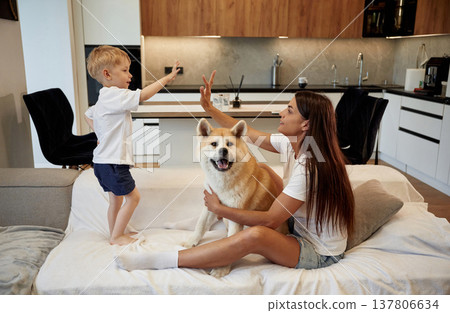 High five hands gesture. Mother with son and Shibu Inu dog are at home High five hands gesture. Mother with son and Shibu Inu dog are at home 137806634