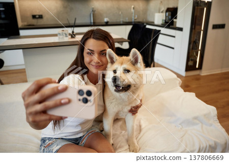 Making a selfie. Woman is with her Shibu Inu dog at home Making a selfie. Woman is with her Shibu Inu dog at home 137806669