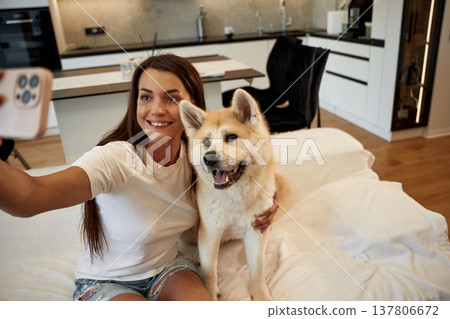 Making a selfie. Woman is with her Shibu Inu dog at home Making a selfie. Woman is with her Shibu Inu dog at home 137806672