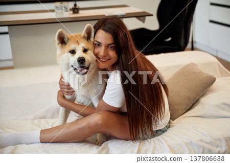 Embracing the pet. Woman is with her Shibu Inu dog at home Embracing the pet. Woman is with her Shibu Inu dog at home 137806688