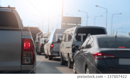 Rear side of pickup car driving on the road. With turn on brake light with many cars stop by traffic jam. Under blue and bright sky. 137807422