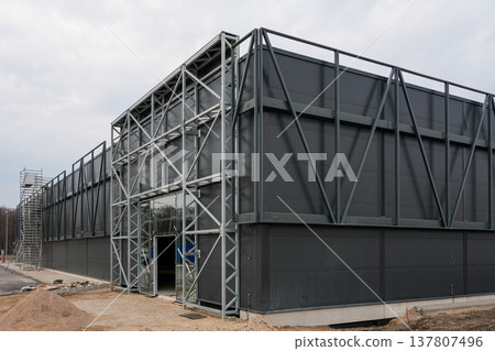 Modern Industrial Warehouse Under Construction with Steel Frame and Dark Metal Facade Exterior 137807496