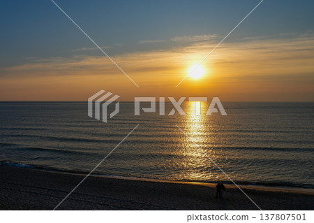 Golden Sunset Over Baltic Sea with Couple Walking Along Quiet Sandy Beach at Evening Horizon Golden Sunset Over Baltic Sea with Couple Walking Along Quiet Sandy Beach at Evening Horizon 137807501