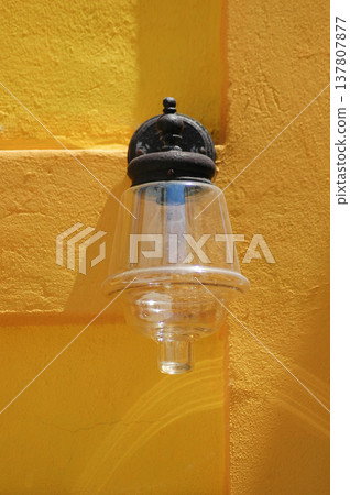 Vintage Glass Wall Lamp on Yellow Stucco 137807877