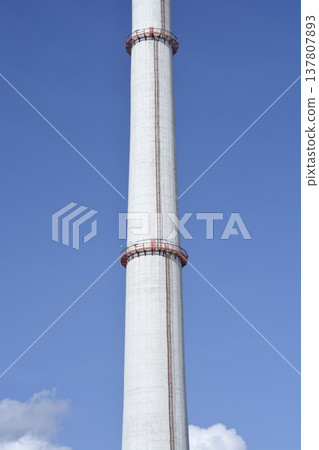 High industrial concrete chimney with red maintenance platforms 137807893
