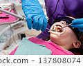 Child receiving dental treatment in a modern clinic with bright lights and caring professionals during a routine checkup 137808074