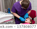 Young girl receiving dental care from a professional in a bright clinic during a routine check-up with a focus on comfort and patient care 137808077