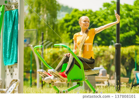 Girl doing exercises outdoor, taking selfie Girl doing exercises outdoor, taking selfie 137808101