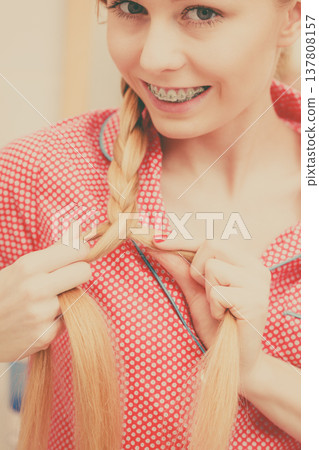 Woman doing braid on blonde hair Woman doing braid on blonde hair 137808157