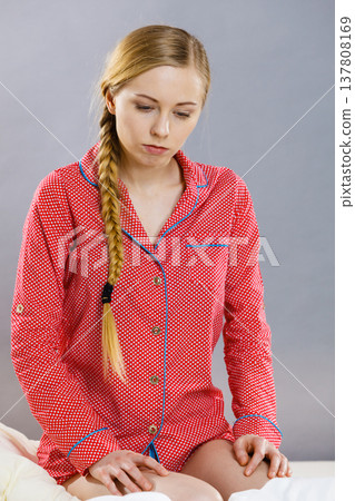 Sad young teenager woman sitting on bed Sad young teenager woman sitting on bed 137808169