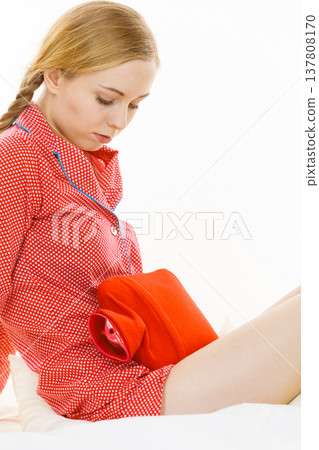 Woman feeling stomach cramps lying on bed Woman feeling stomach cramps lying on bed 137808170