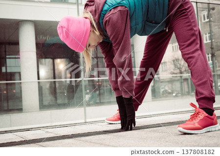 Sporty girl stretching outdoor on city street. 137808182