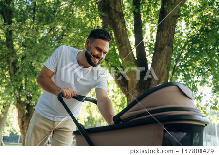 Very happy, parenting conception. Father is with cradle, having a walk in the park 137808429