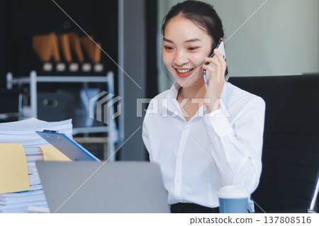 Charming smiling adult woman middle aged woman with curly hair architect designer working on computer in the bright modern office Charming smiling adult woman middle aged woman with curly hair architect designer working on computer in the bright modern office 137808516