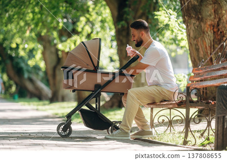 Father is with cradle, having a walk in the park Father is with cradle, having a walk in the park 137808655