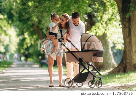 Couple is with daughter and cradle are having a walk 137808756