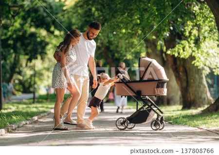 Having a good walk. Couple is with daughter and cradle Having a good walk. Couple is with daughter and cradle 137808766