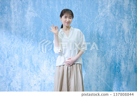 A woman in her 60s smiling and looking at the camera. 137808844