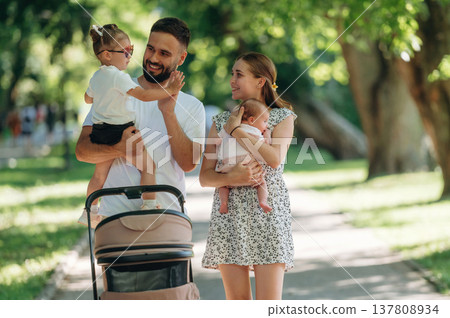 Care conception, holding baby. Couple is with daughter, newborn baby and cradle are having a walk 137808934