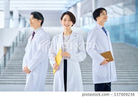 醫院大廳裡，一群醫生和醫護人員面帶微笑。 137809236