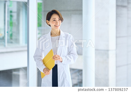 Japanese women in white coats smiling in a hospital corridor. Doctors, pharmacists, researchers. 137809237