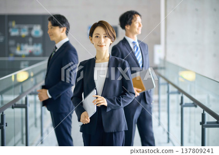 A Japanese businesswoman and her team exude confidence in the office. 137809241