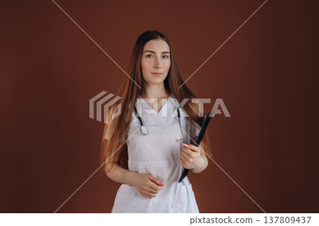 Notepad is in hand. Female doctor is in the studio Notepad is in hand. Female doctor is in the studio 137809437