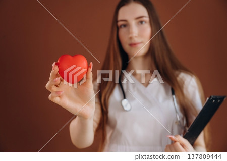 Little red heart, cardiologist. Female doctor is in the studio Little red heart, cardiologist. Female doctor is in the studio 137809444
