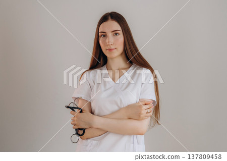 Standing with arms crossed. Female doctor is in the studio Standing with arms crossed. Female doctor is in the studio 137809458