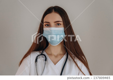 With facial mask. Female doctor is in the studio With facial mask. Female doctor is in the studio 137809465