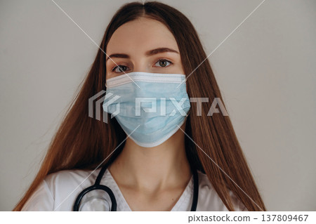 With facial mask. Female doctor is in the studio With facial mask. Female doctor is in the studio 137809467