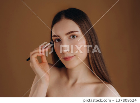 Make up, cosmetics conception. Young woman is against background Make up, cosmetics conception. Young woman is against background 137809524