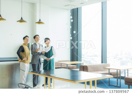 A male craftsman wearing an air-conditioned suit having a meeting while looking at documents A male craftsman wearing an air-conditioned suit having a meeting while looking at documents 137809567
