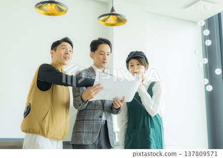 一位身穿空調西裝的男工匠正在開會，同時查看文件。 137809571