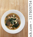 Chicken noodle soup Asian soup clear broth sliced chicken green vegetable comfort food homemade meal hot soup white bowl wooden table 137809754