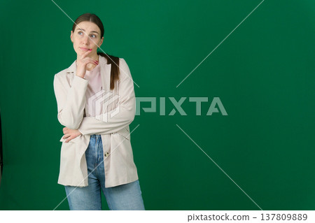 Various emotions and poses of a woman in a beige jacket and jeans, wearing a pink European T-shirt with her hair pulled back into a ponytail, against a green background 137809889