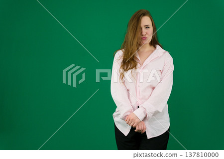 Various emotions and movements of a woman in a pink shirt and black pants on a green background. A European woman with a round face. Various poses. 137810000