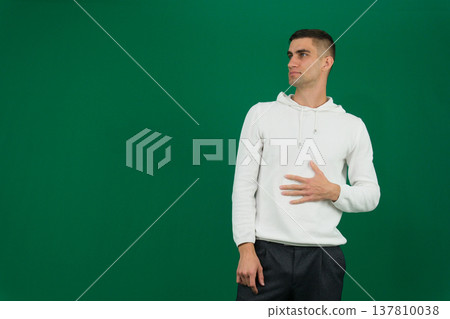 Close-up photo of a young Indian man in an office, holding a napkin and feeling unwell. Close-up photo of a young Indian man in an office, holding a napkin and feeling unwell. 137810038