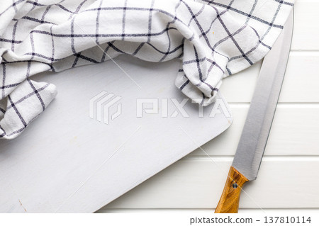 White Wooden Cutting Board With Checkered Kitchen Towel And Chef Knife On White Counter White Wooden Cutting Board With Checkered Kitchen Towel And Chef Knife On White Counter 137810114