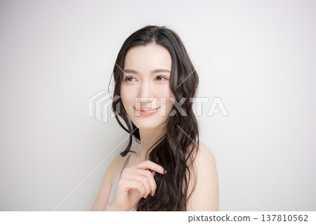 一位長著黑色燙髮的女子在白色背景下飄逸;這是一張關於頭髮護理和治療的圖片。 一位長著黑色燙髮的女子在白色背景下飄逸;這是一張關於頭髮護理和治療的圖片。 137810562