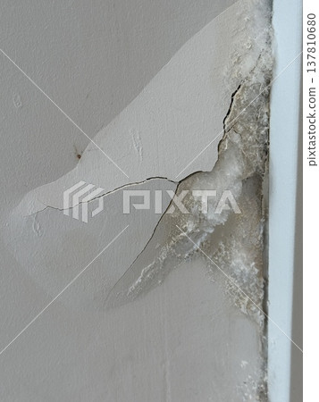 Water damage on cracked ceiling with mold and paint peeling, suitable for background use 137810680