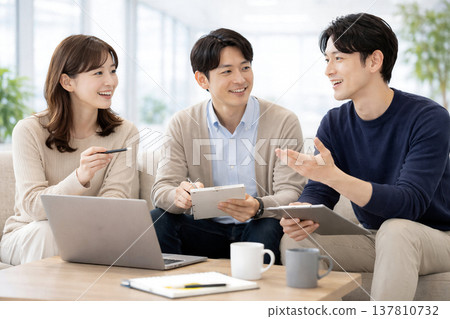 A startup team casually holds a meeting in the office lounge. 137810732