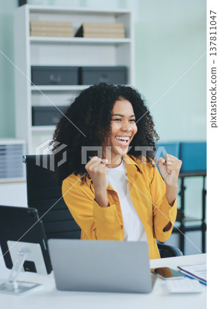 Pretty female freelancer working on laptop while sitting on modern coworking background 137811047